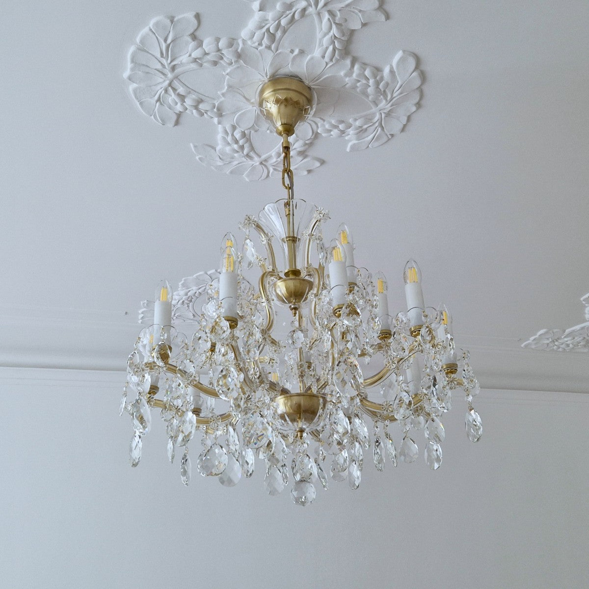 Crystal chandelier hanging from a decorative ceiling