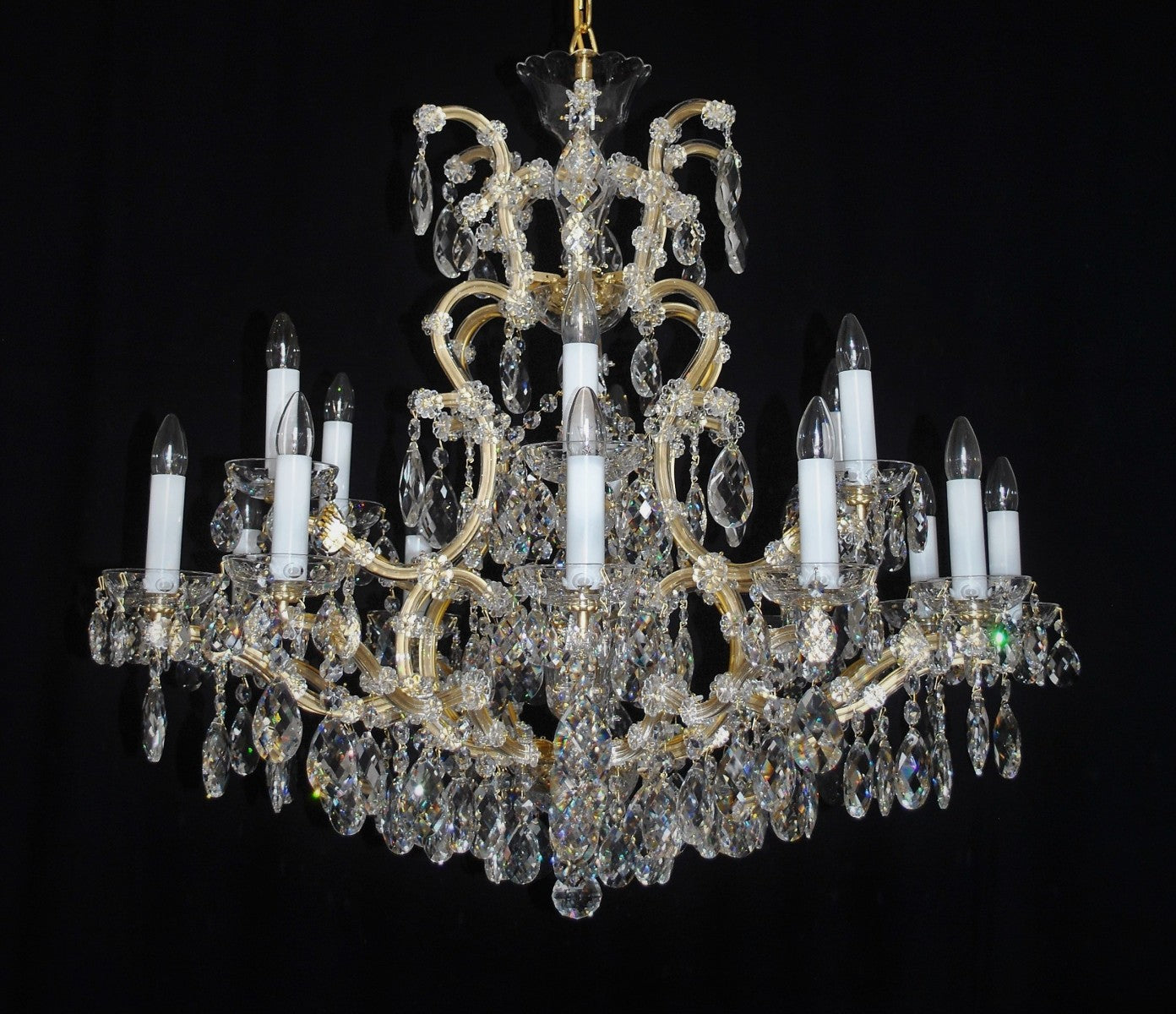 Crystal chandelier with multiple candle-style lights on a black background