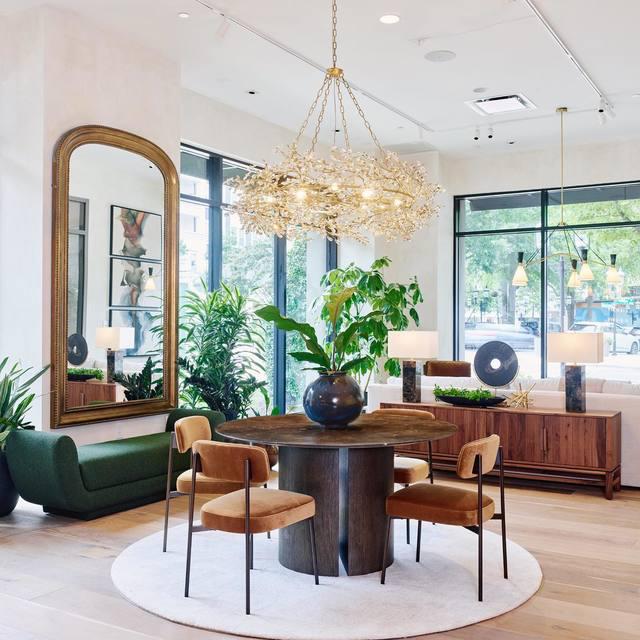 Modern dining room with a round wooden table, chairs, and decorative elements.