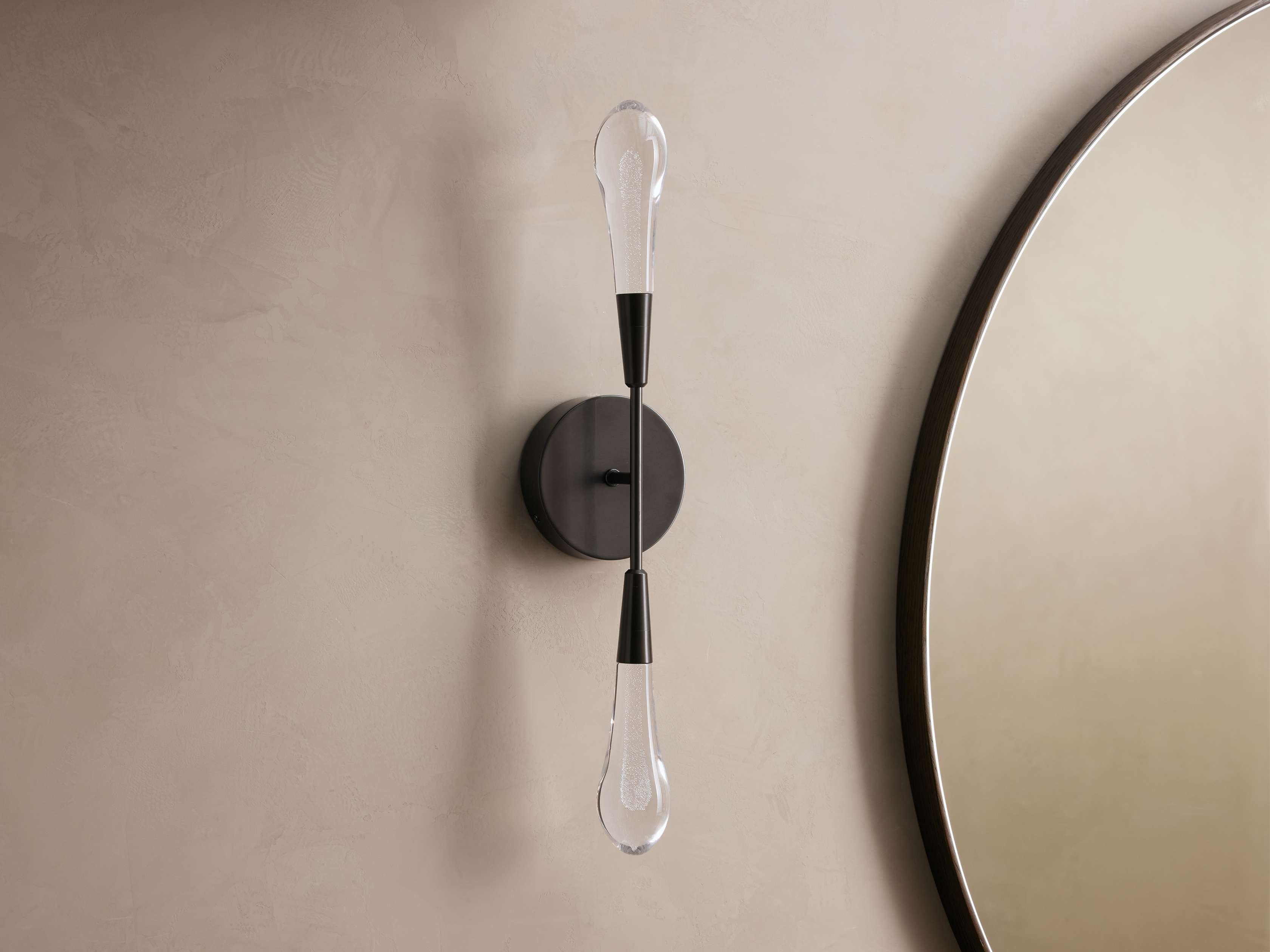 Wall-mounted light fixture with a round mirror on a beige wall