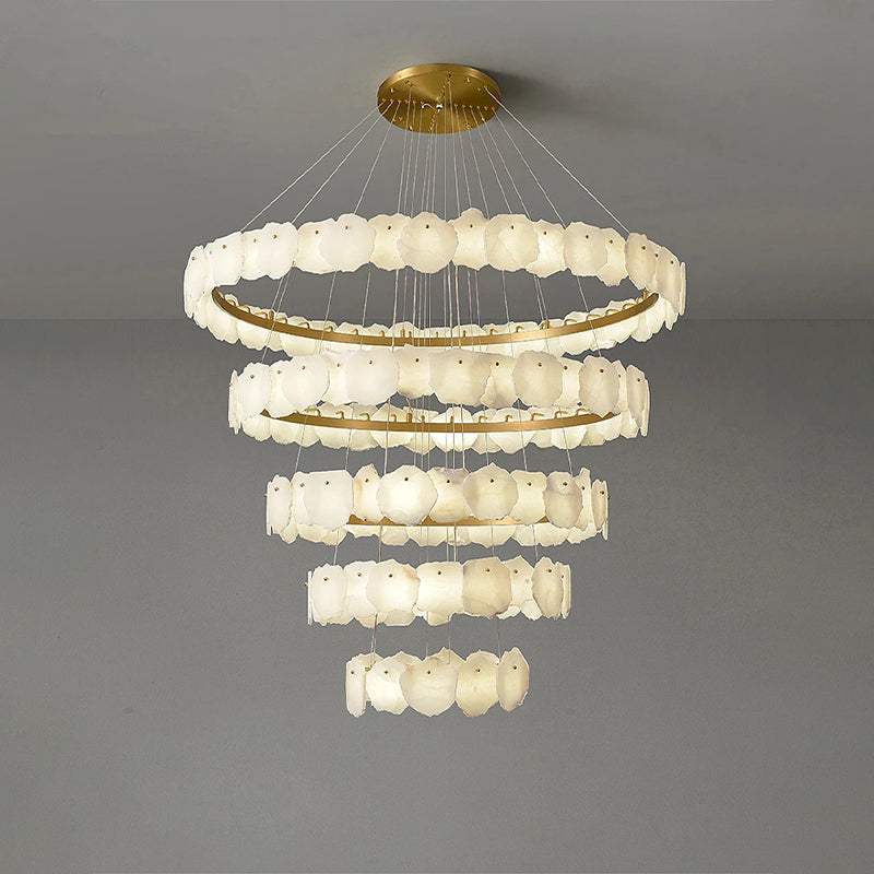 Chandelier with multiple tiers of circular lights on a gray background