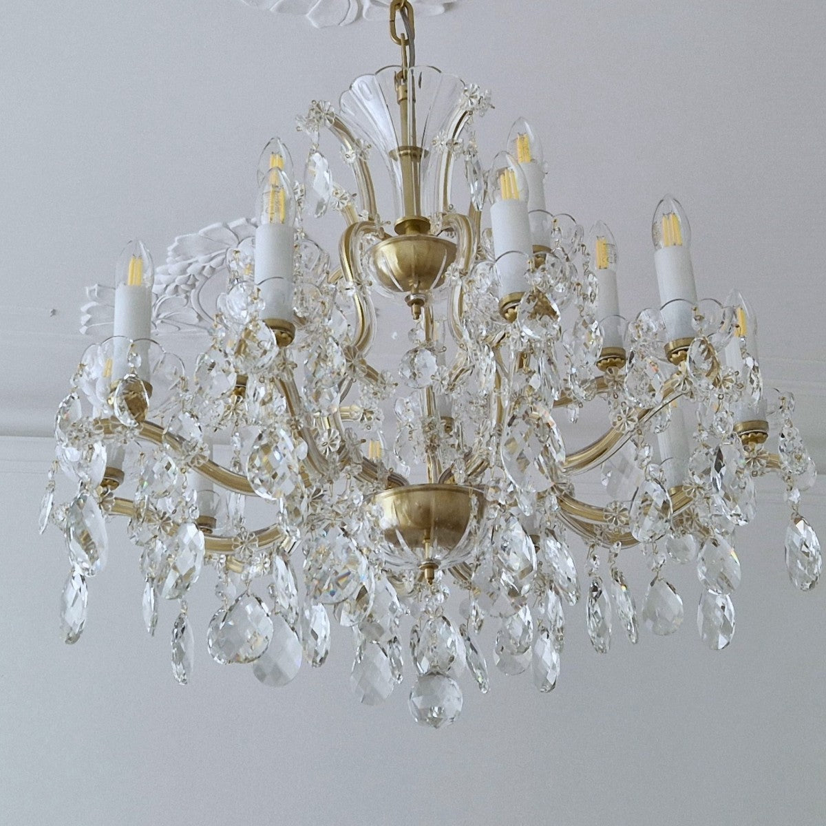 Crystal chandelier with gold accents on a plain background