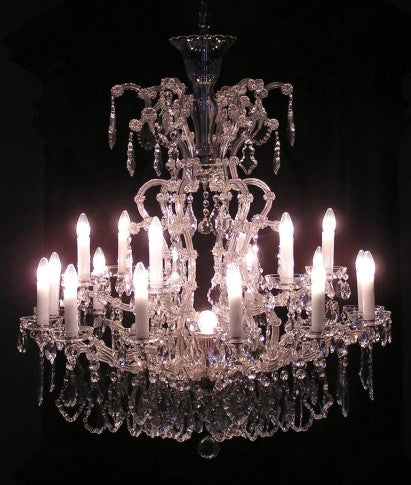 Crystal chandelier with multiple candles against a dark background