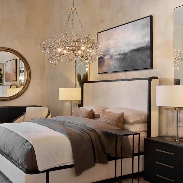 Luxurious bedroom with a chandelier, bed, and wall art.