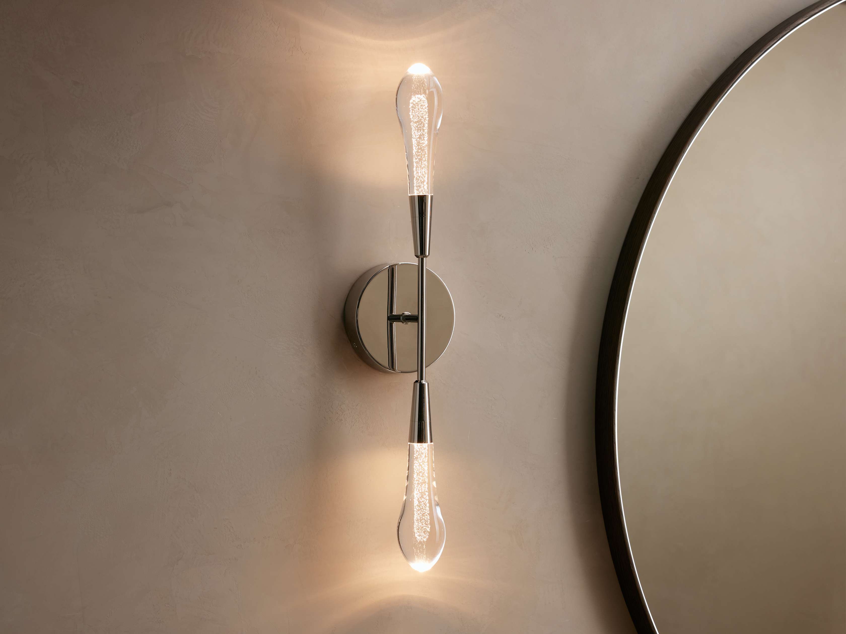 Modern wall sconce with two light bulbs on a neutral wall.
